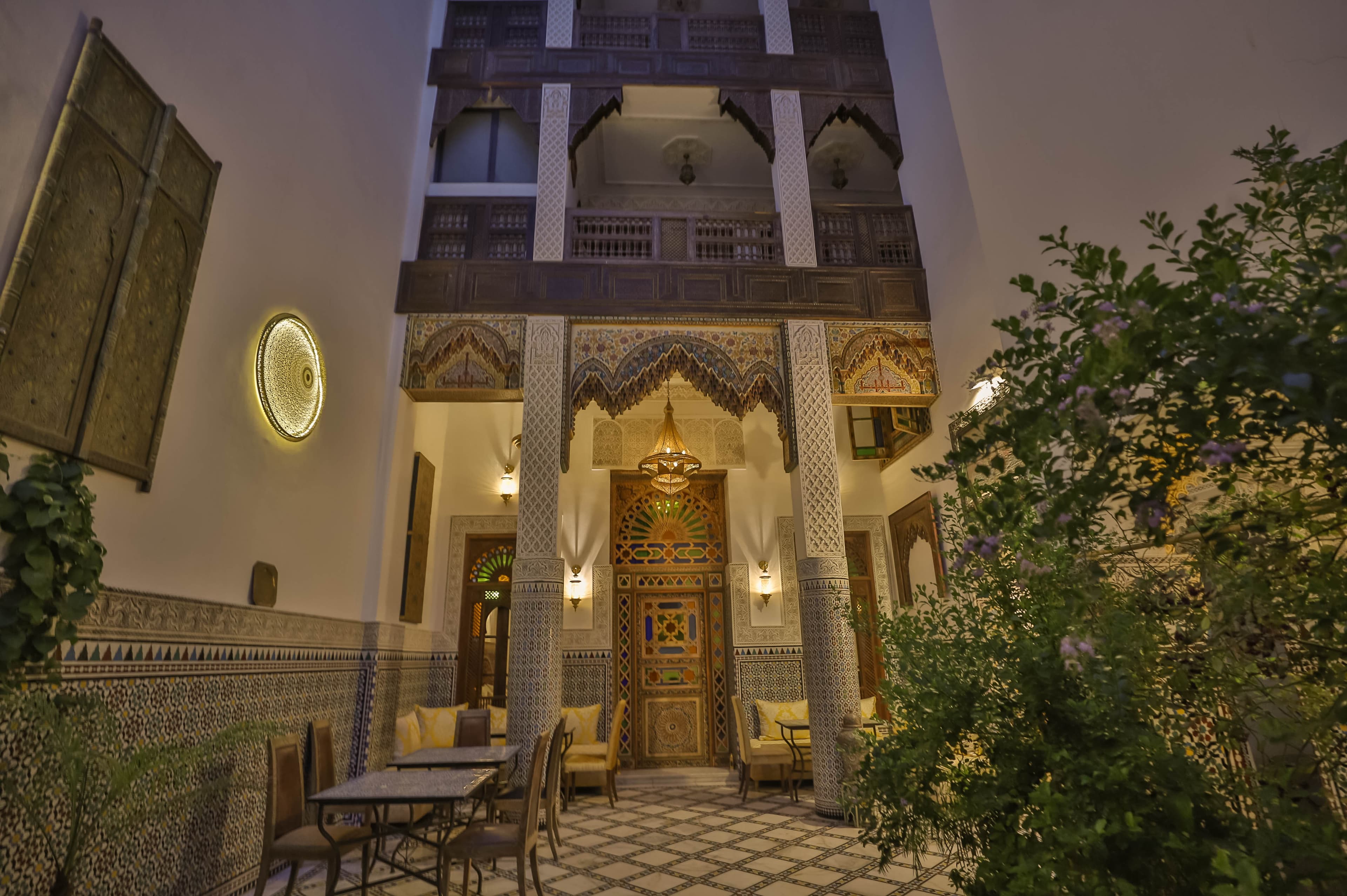 Riad Fez Mahal — ornate carved wooden entrance at night